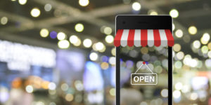 Ein Blick durch ein Smartphone auf einen Shop als Sinnbild für Google my Business, das digitale Schaufenster.