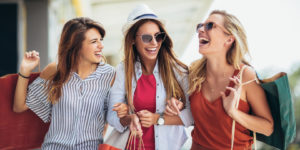 Drei junge Frauen shoppen in Geschäften, die sie durch Local SEO gefunden haben.
