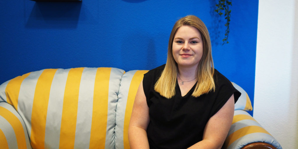 Johanna, Auszubildende als Kauffrau für Marketingkommunikation bei forty-four, sitzt auf einer Couch.