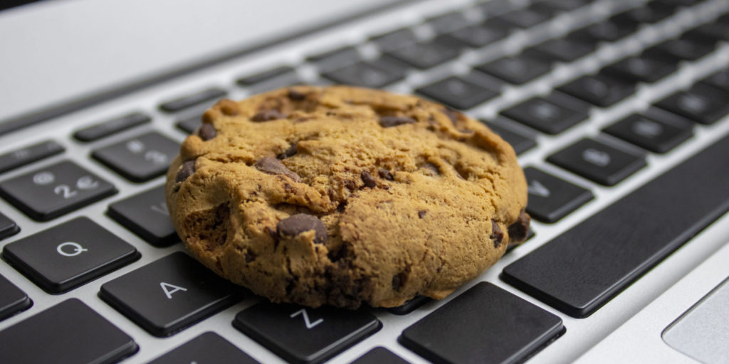 Ein Keks liegt auf einem Laptop als Sinnbild für die TTDSG Cookies.